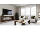 Bright living room featuring white armchairs, a wooden coffee table, and a large window at 136 Fairport Ln, Apex, NC 27539