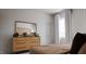 Comfortable main bedroom with a dresser, neutral decor, and a well-lit window at 136 Fairport Ln, Apex, NC 27539
