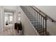 Stairway with hardwood treads, black iron spindles, and views to other rooms at 136 Fairport Ln, Apex, NC 27539