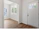Bright entryway with hardwood floors and a white front door with sidelight windows at 1408 South St, Durham, NC 27707