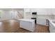 Bright kitchen with island, white cabinetry, stainless appliances, and hardwood floors at 1408 South St, Durham, NC 27707