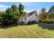 Exterior view of a two-story home with painted brick, mature trees, a garden and a spacious lawn at 1431 Courtland Dr, Raleigh, NC 27604