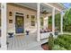 Inviting front porch with a swing, elegant columns, ceiling fan, and ample space for relaxing and entertaining at 1431 Courtland Dr, Raleigh, NC 27604