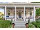 Inviting covered front porch with elegant white columns, comfortable seating, and beautiful landscaping at 1431 Courtland Dr, Raleigh, NC 27604