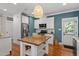 Spacious kitchen with stainless appliances, custom island, and stylish accent wall at 1431 Courtland Dr, Raleigh, NC 27604
