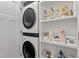 Convenient laundry room featuring stacked washer and dryer and storage shelves at 1431 Courtland Dr, Raleigh, NC 27604