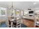 Bright living room flows from dining area; featuring a fireplace, hardwood floors, and modern ceiling fan at 1431 Courtland Dr, Raleigh, NC 27604