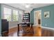 Bright home office with a large window, glass desk, hardwood floors, and built-in bookcase at 1431 Courtland Dr, Raleigh, NC 27604