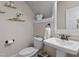 Charming powder room with pedestal sink, decorative shelves, and modern fixtures at 1431 Courtland Dr, Raleigh, NC 27604