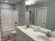 Well-lit bathroom featuring a double vanity, shower with tub, and neutral color scheme at 145 Plantation Dr, Youngsville, NC 27596