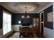 Charming dining room features dark blue walls, wainscoting, and elegant chandelier fixture with abundant light at 145 Plantation Dr, Youngsville, NC 27596