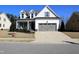 Inviting two-story home with a two-car garage, manicured lawn, and a paved driveway at 145 Plantation Dr, Youngsville, NC 27596
