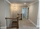Upstairs hallway with neutral carpet, and a decorative light fixture at 145 Plantation Dr, Youngsville, NC 27596
