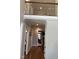 Hallway with hardwood floors and white trim leads to staircase, living room, and bathroom at 145 Plantation Dr, Youngsville, NC 27596