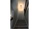 Staircase features stained wood treads, white risers, and decorative wrought iron railing, and modern light fixture at 145 Plantation Dr, Youngsville, NC 27596