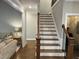Staircase with wood and wrought iron railing connects to the upper level with a view into the living room at 145 Plantation Dr, Youngsville, NC 27596
