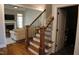 Staircase with wrought iron railing leads to open-concept living room featuring a fireplace at 145 Plantation Dr, Youngsville, NC 27596