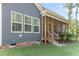 Home exterior with screened-in back porch, wooden steps, and a well-maintained lawn at 1520 Banks Brooke Dr, Raleigh, NC 27603