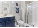 Bathroom featuring blue vanity, white toilet, shower, and decorative blue and white hand towel at 1520 Banks Brooke Dr, Raleigh, NC 27603