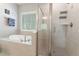 Bright bathroom boasts a separate glass shower and a soaking tub set beneath a window with natural light at 1520 Banks Brooke Dr, Raleigh, NC 27603