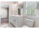 Well-lit bathroom with a double vanity, a large mirror, and a window at 1520 Banks Brooke Dr, Raleigh, NC 27603
