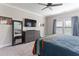 Bedroom with ceiling fan, large dresser, mounted television, and a colorful striped blanket on the bed at 1520 Banks Brooke Dr, Raleigh, NC 27603