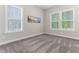 Neutral bedroom with carpet, picture, and two large windows with blinds at 1520 Banks Brooke Dr, Raleigh, NC 27603