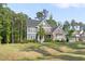 Beautifully landscaped two-story home with stone and siding, surrounded by mature trees at 1520 Banks Brooke Dr, Raleigh, NC 27603