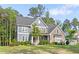Charming two-story home with stone and siding, surrounded by mature trees and a manicured lawn at 1520 Banks Brooke Dr, Raleigh, NC 27603