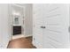 Hallway view with wood floors leading to bathroom with dark vanity and view of stairway at 1520 Banks Brooke Dr, Raleigh, NC 27603