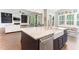 Open kitchen with an island, breakfast bar, farm sink, and stainless steel dishwasher at 1520 Banks Brooke Dr, Raleigh, NC 27603
