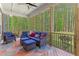 Screened-in porch with cozy seating and views of the green, wooded backyard at 1520 Banks Brooke Dr, Raleigh, NC 27603