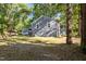 Spacious backyard and exterior with gray house, shed, and mature trees at 1613 Kilmer Ter, Durham, NC 27703