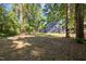 Exterior of home and back yard showing gray house, shed, mature trees at 1613 Kilmer Ter, Durham, NC 27703