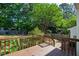 Lush backyard featuring a wooden deck, string lights, and mature trees for privacy at 2 Great Oak Ct, Durham, NC 27713