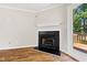 Living room fireplace with hardwood floors, white mantle, and access to outdoor patio at 2 Great Oak Ct, Durham, NC 27713