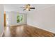 Living room featuring hardwood floors, ceiling fan, and large window with a view of greenery at 2 Great Oak Ct, Durham, NC 27713