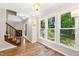 Living room area with hardwood flooring, many windows, and a staircase at 2 Great Oak Ct, Durham, NC 27713