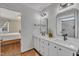 Bright bathroom featuring double sinks, white cabinets, modern fixtures, and access to the primary bedroom at 2006 Woodstone Dr, Archer Lodge, NC 27527