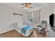 Cozy bedroom with wood-look floors, a ceiling fan, and a large window offering ample natural light at 2006 Woodstone Dr, Archer Lodge, NC 27527