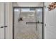 Modern shower with stone floor, window, and sleek black fixtures in a bright and airy bathroom at 2006 Woodstone Dr, Archer Lodge, NC 27527