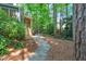 Landscaped backyard featuring a stone pathway leading to the porch and lush foliage at 2018 Waterton Ln, Apex, NC 27502