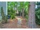 Picturesque backyard with stone pathway, mature trees, and well-maintained landscaping at 2018 Waterton Ln, Apex, NC 27502