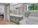 Bathroom with a double sink vanity, tile floor, framed mirror and a window overlooking greenery at 2018 Waterton Ln, Apex, NC 27502
