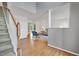 Bright foyer featuring hardwood floors, staircase, and an open view to the living room at 2018 Waterton Ln, Apex, NC 27502