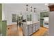 Open concept of kitchen, dining area, kitchen island with hardwood floors, and lots of windows at 2018 Waterton Ln, Apex, NC 27502