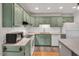 Traditional kitchen with light green cabinets, white subway tile, stainless steel appliances, and granite countertops at 2018 Waterton Ln, Apex, NC 27502