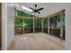Relaxing screened porch featuring a ceiling fan, skylight, and natural wood flooring at 2018 Waterton Ln, Apex, NC 27502