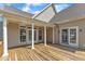 Back porch featuring wood flooring, white columns, ceiling fans, and access doors at 202 Reeder Branch Dr, Clayton, NC 27520