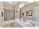 Bright bathroom featuring double sinks, large mirror, and a shower-tub combo, creating a functional space at 202 Reeder Branch Dr, Clayton, NC 27520